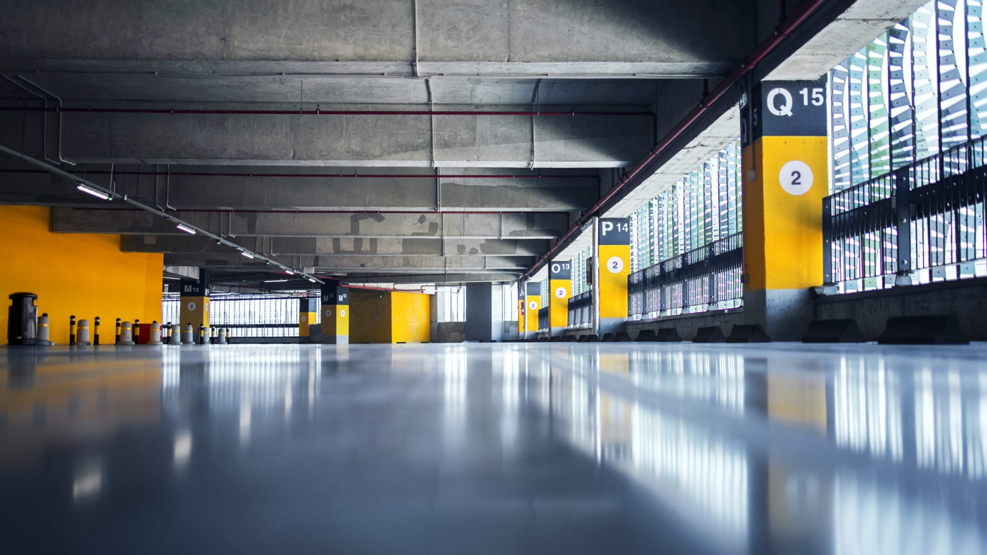 Empty garage with parking lots with concrete ceiling and flooring and pillars marked with numbers.